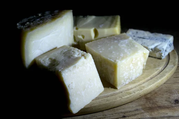 Surtido Quesos Una Tabla Cortar Madera Claroscuro Luz — Foto de Stock