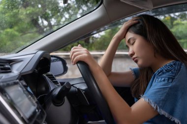Stressed woman drive car feeling sad and angry. Asian girl tired, fatigue on car. Driver tired drows drink dont drive concept. Sleepy and drunk female hangover. Illegal law driver license. clipart