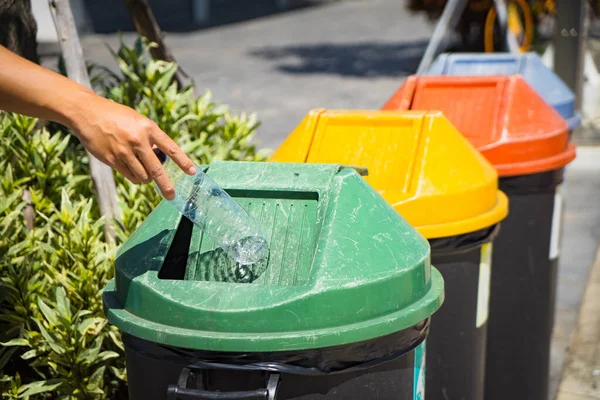 Waste management, Man hand throwing plastic bottle into recycle bin. Waste separation rubbish before drop to garbage bin to save the world, environment care. Pollution trash recycling management concept.