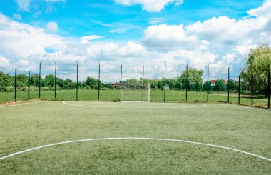 Mavi gökyüzüne karşı küçük bir köyde futbol sahası
