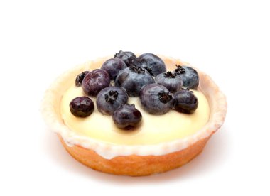 Beyaz arka planda yaban mersinli panna cotta.