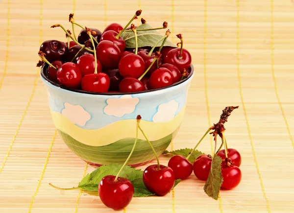 Ripe red cherries on the table and in the cup. — Stock Photo, Image