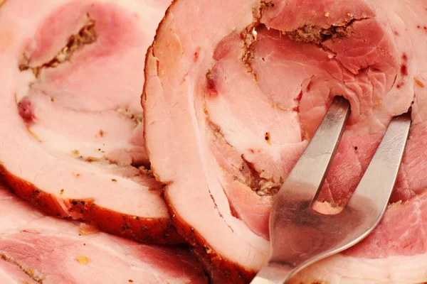 Sliced ??ham close up. Fork in the meat. — Stock Photo, Image