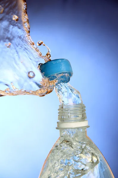 Een splash van water uit een fles. — Stockfoto