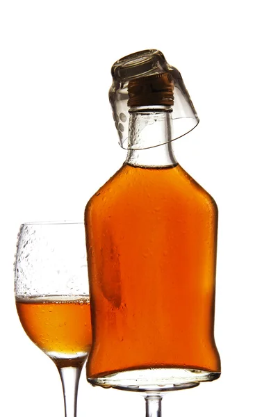 Vidrio y botella de alcohol sobre un fondo blanco . — Foto de Stock