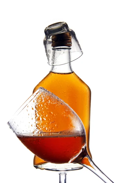 Glass and bottle of alcohol on a white background. — Stock Photo, Image