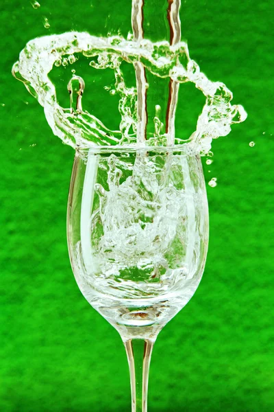 Strumień wody spada do szkła. — Zdjęcie stockowe