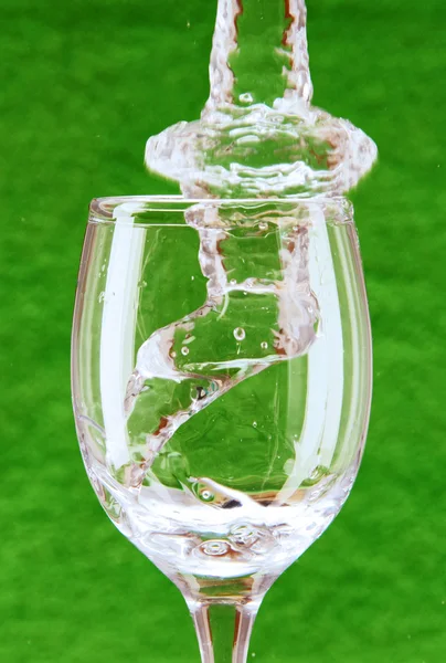 Strumień wody spada do szkła. — Zdjęcie stockowe