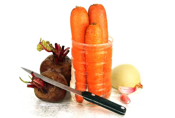 Duas beterrabas cruas, três cenouras, cebola e uma faca . — Fotografia de Stock