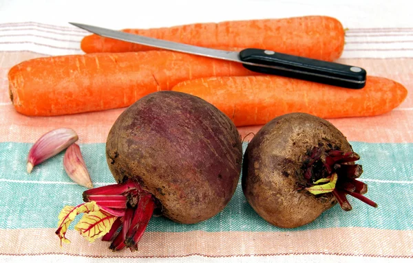 Dos remolachas crudas, tres zanahorias y un cuchillo . — Foto de Stock