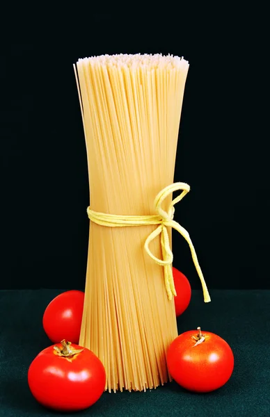 Espaguete cru com tomates . — Fotografia de Stock