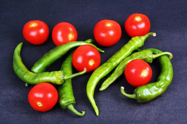Pods of green hot peppers and red tomatoes. — Stock Photo, Image