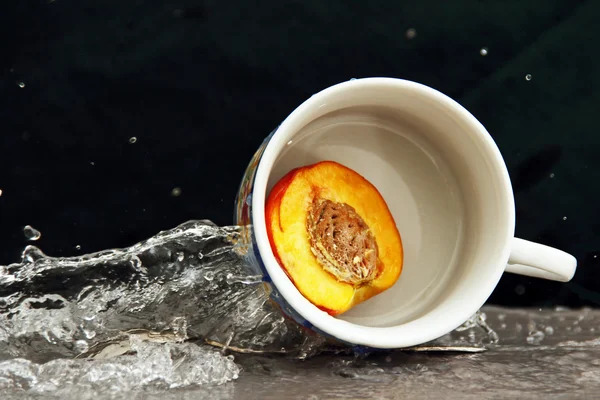 Çay bir fincan bir dilim şeftali suyu akışı. — Stok fotoğraf