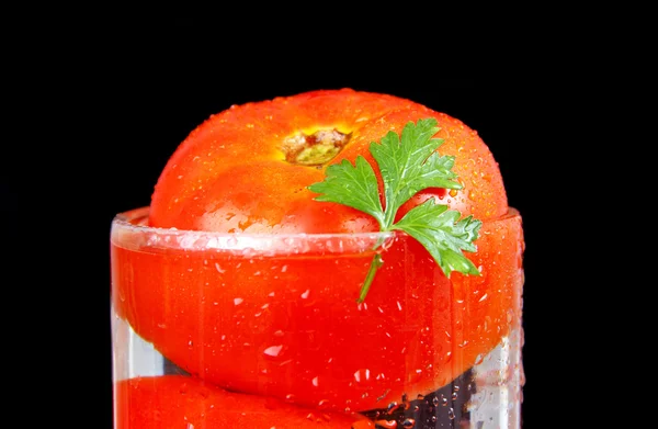 Tomat i ett kärl med vatten. — Stockfoto