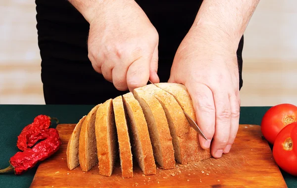 Cook snijdt het brood. — Stockfoto