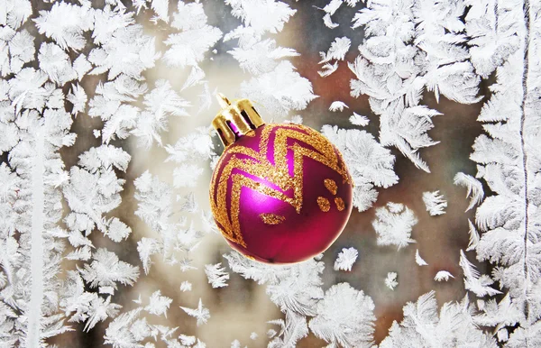 Christmas tree toy on the background of frost patterns. — Stock Photo, Image