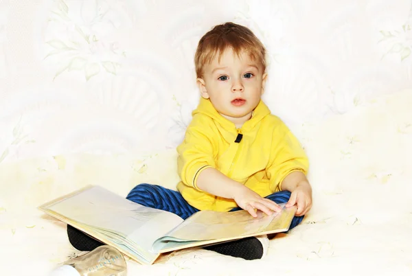 Kid volter igenom en bok. — Stockfoto