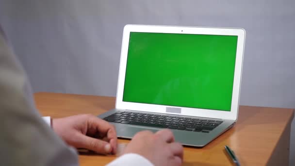 Un joven trabajando en una computadora de pantalla verde — Vídeo de stock