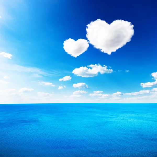 Mar azul bajo las nubes cielo con forma de corazón nube de fondo —  Fotos de Stock