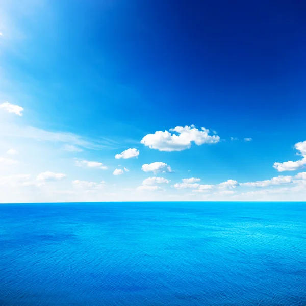 Mar azul bajo las nubes cielo — Foto de Stock