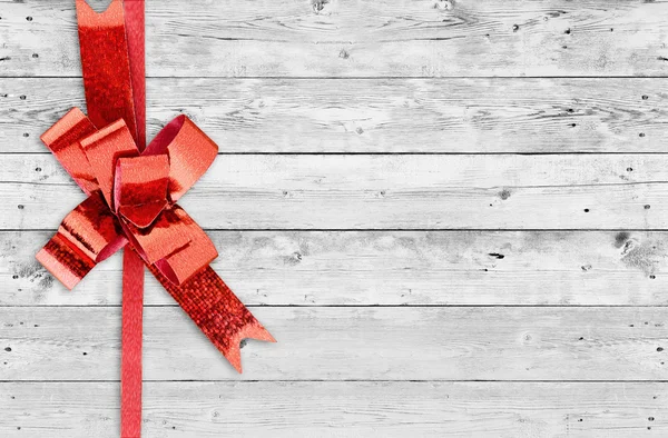 Red Christmas bow on grunge wooden background with space for text — Stock Photo, Image