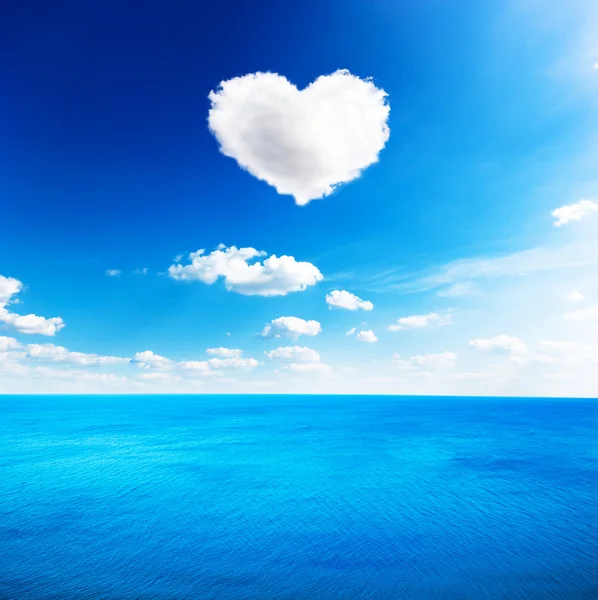 Mar azul bajo las nubes cielo con forma de corazón nube de fondo — Foto de Stock