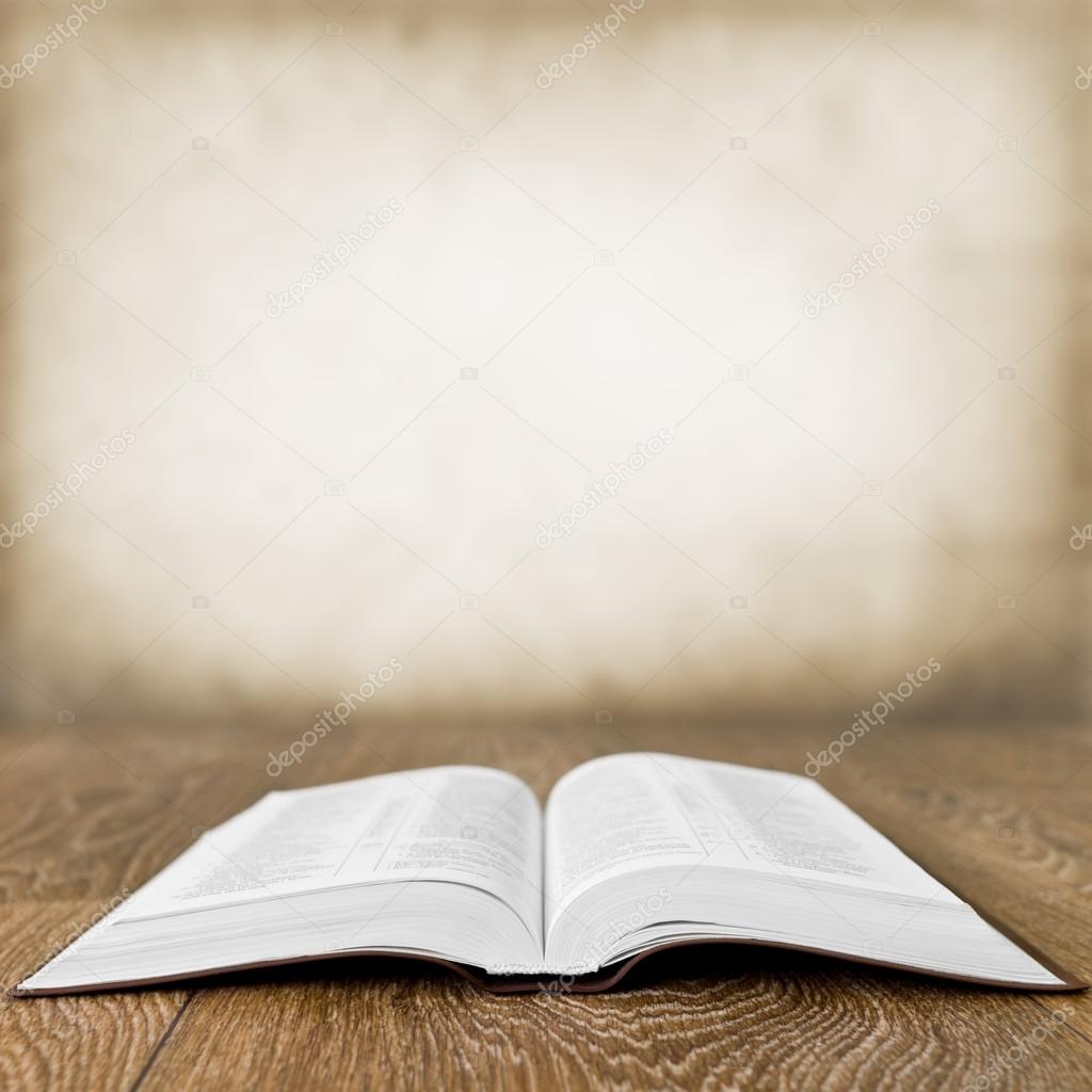 Open book on wood table over grunge background