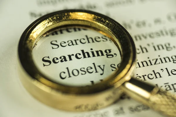 Searching Concept With Closeup Golden Magnifying Glass Stock Picture