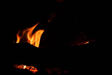 Siyah bir arkaplanda alevler içinde yanan kömürleri