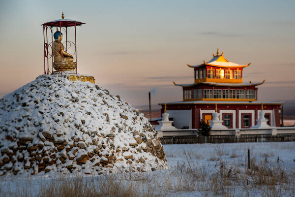 statues of Buddhist deities against the backdrop of snow-capped mountains, horizontally