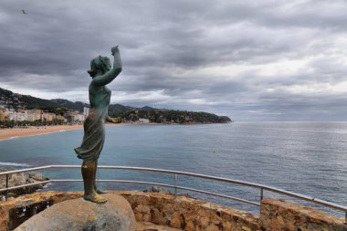 LLORET DE MAR, İspanya - 6 Ekim 2021: Dona Marinera (Balıkçının Eşi) kamu alanı anıtı. Bronz heykel 1966 yılında sanatçı Ernest Maragall tarafından yaptırıldı..