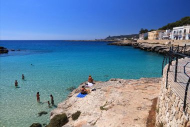 APULIA, İtalya - 30 Mayıs 2017: Puglia bölgesindeki Santa Maria Al Bagno plajını ziyaret edenler. Yıllık 50 milyon ziyaretçiyle İtalya, en çok ziyaret edilen ülkelerden biri oldu..