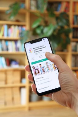 WARsaw, POLAND - 29 Ocak 2021: Kullanıcı bir Android OS, Xiaomi markalı akıllı telefona Faceapp güzellik ve makyaj uygulaması yüklüyor.