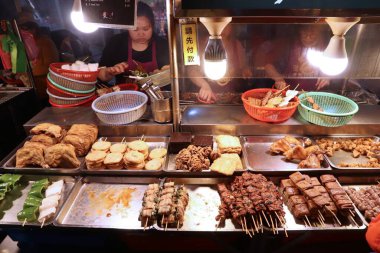 KEELUNG, TAIWAN - 22 Kasım 2018: Satıcılar Keelung, Tayvan 'daki Miaokou Gece Pazarı' nda yemek hazırlıyorlar. Gece pazarları Tayvan gıda kültürünün önemli bir parçasıdır..