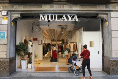 BARCELONA, İspanya - 7 Ekim 2021: İnsanlar Barselona şehir merkezindeki Carrer de Pelai alışveriş caddesindeki Mulaya moda mağazasını ziyaret ediyor.
