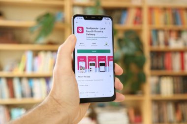SAVAŞ, POLAND - 29 HAZİRAN 2021: Android OS, Xiaomi akıllı telefona Foodpanda yiyecek ve market dağıtım uygulaması yükleyen kullanıcı.