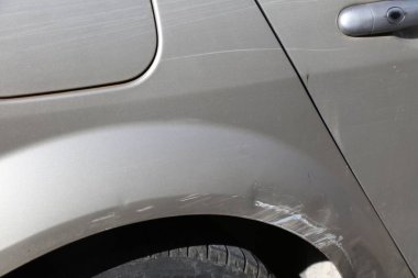 Yan tarafında çizik olan sıradan bir araba. Ufak bir kaza sonucu, ufak bir kaza..