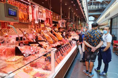 BARCELONA, İspanya - 8 Ekim 2021: İnsanlar İspanya 'nın Barcelona kentindeki Mercat de Sant Antoni pazarındaki kasap standını ziyaret ediyor.