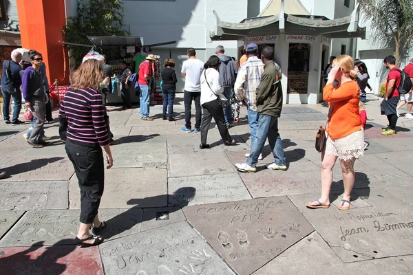 Los Angeles Usa エイプリル社2014年5月5日 ハリウッドのTclチャイニーズ シアターの前で著名人の手版画を鑑賞する人がいます 劇場には200近くの有名人の手版画と足跡のコレクションがあります — ストック写真