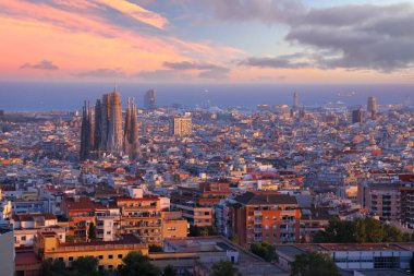 Arka planda Sagrada Familia ve Akdeniz ile Barselona şehir manzarası. İspanya 'nın Barcelona kentinin gün batımı manzarası.