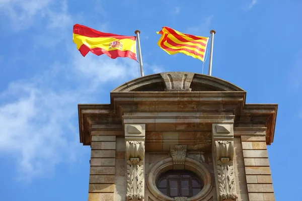 スペインの旗とカタルーニャの旗は バルセロナのカタルーニャ議会の上に風の中で並んで — ストック写真