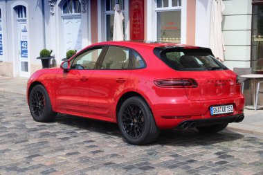 DRESDEN, ALMANY - 10 Mayıs 2018: Porsche Macan Almanya 'da park edilmiş kırmızı lüks SUV aracı. Almanya 'da kayıtlı 45.8 milyon araç bulunmaktadır (2017 itibariyle).).
