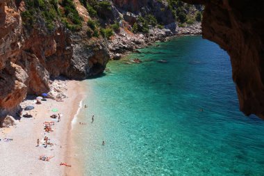 KONAVLE, CROATIA - 28 Haziran 2019: İnsanlar Hırvatistan 'ın Dalmaçya bölgesindeki Konavle bölgesindeki kayalıkların altındaki Pasjaca plajında tatil yapıyorlar.