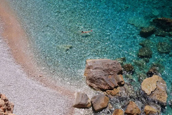 克罗地亚夏季 科纳维尔悬崖下的帕斯卡海滩在清澈的水中游泳的女游客 — 图库照片