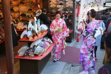 KYOTO, JAPONYA - 26 Kasım 2016: Kyoto, Japonya 'daki Higashiyama eski kasabasındaki geleneksel kostüm uzmanı hayran dükkanındaki kadınlar. Kyoto 'nun 17 UNESCO Dünya Mirası Alanı var.