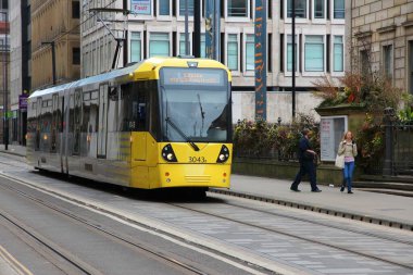 Manchester, İngiltere - 21 Nisan 2013: İnsanlar Manchester Manchester, İngiltere'de tramvayla. Manchester Metrolink hizmet veren 21 milyon rides her yıl (2011).
