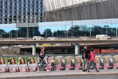 STOCKHOLM, SWEDEN - 23 Ağustos 2018: İsveç genel seçimlerinden önce insanlar Centerpartiet (Merkez Partisi) ve Socialdemokraterna (Sosyal Demokrat Parti) siyasi posterlerinden geçmektedir.