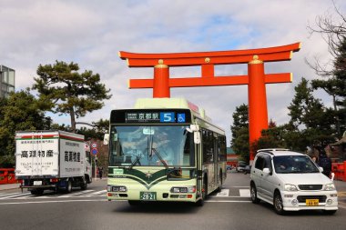 KYOTO, JAPONYA - 24 Kasım 2016: Japonya 'nın en büyük torii kapısının altından belediye otobüsü geçiyor. Kyoto 'nun 17 UNESCO Dünya Mirası Alanı var.