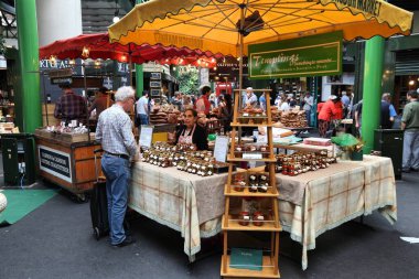 LONDON, İngiltere - 8 Temmuz 2016: İnsanlar Southwark, Londra 'daki Borough Market' ten alışveriş yapıyor. Avrupa 'nın en eski pazarlarından biridir. 1.000 'inci doğum günü 2014' teydi..