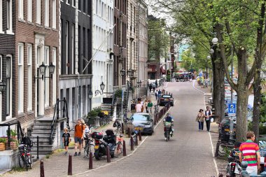 AMSTERDAM, NETHERLANDS - 10 HAZİRAN 2017: insanlar Amsterdam 'da Amstel caddesi boyunca yürüyorlar. Amsterdam Hollanda 'nın başkentidir..